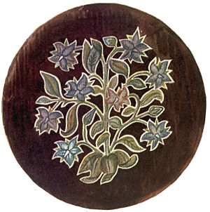 A stool cover showing a flower motif