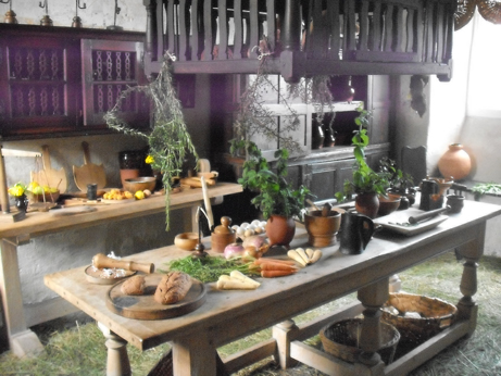 The litchen with fresh herbs on the table and rushes on the floor - really need smell-o-vision here!