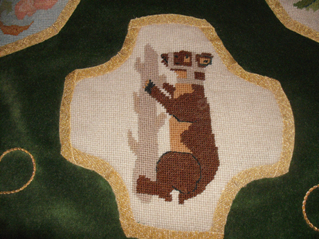 Detail of one of the needlepoint motifs - bear and ragged staff