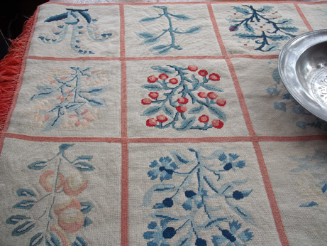 A sadly faded needlepoint runner on one of the tables in the Great Hall