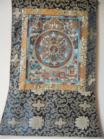 The thanka painting mounted in silk brocade